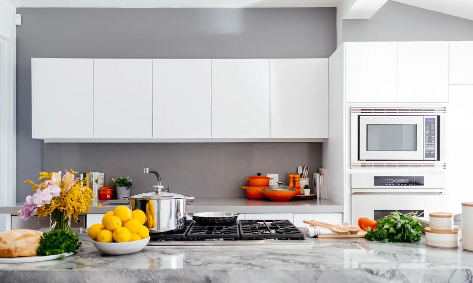 Bright, spotless white kitchen with a bowl of fresh lemons on the counter
