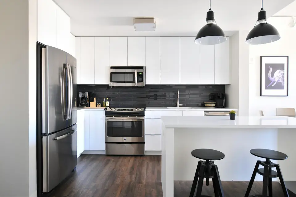 Clean modern kitchen with white cabinets and stainless appliances